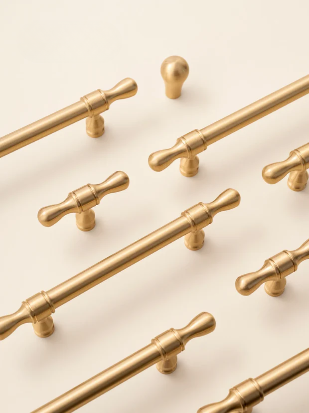 Gold cabinet handles on a beige background
