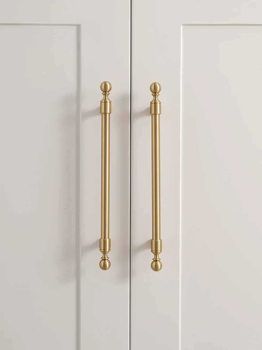 Gold cabinet handles on a white door