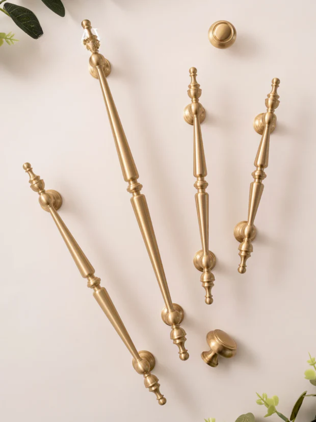 Set of gold cabinet handles on a light background.