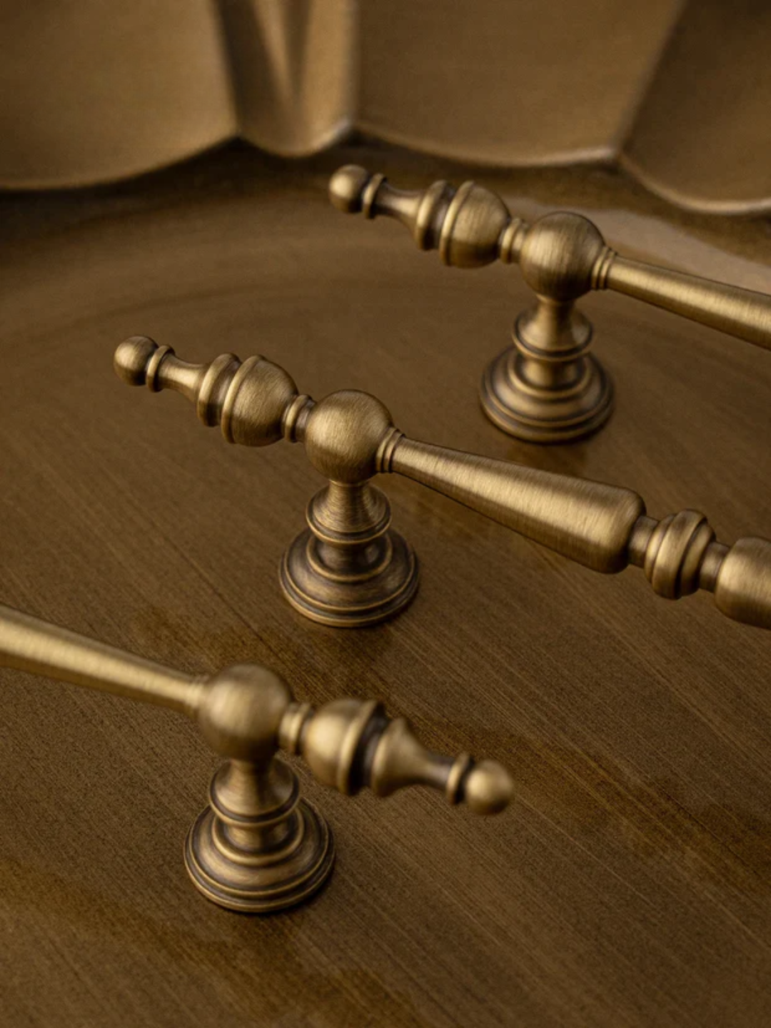 Close-up of brass towel bar fixtures on a wooden surface