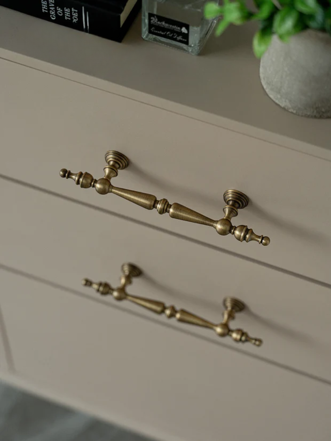 Close-up of a cabinet with brass handles on a neutral background