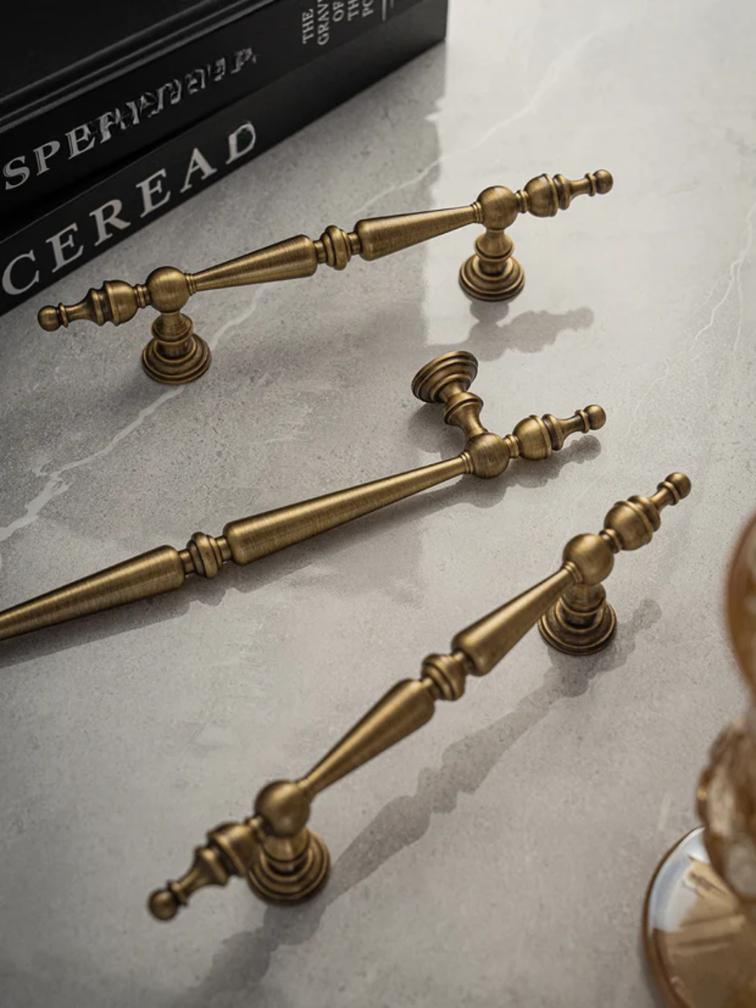 Set of brass cabinet handles and knobs on a marble surface