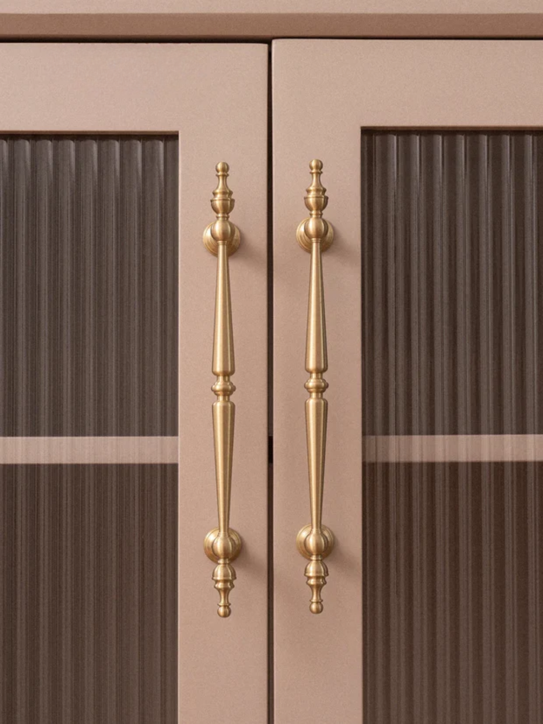 Close-up of a cabinet with gold handles on a beige background