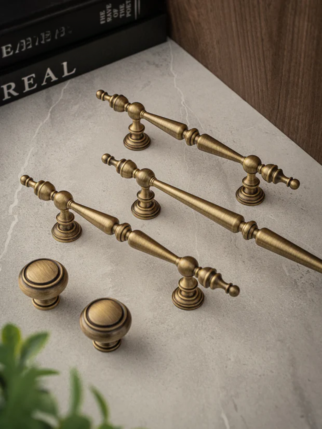 Set of brass cabinet handles and knobs on a marble surface