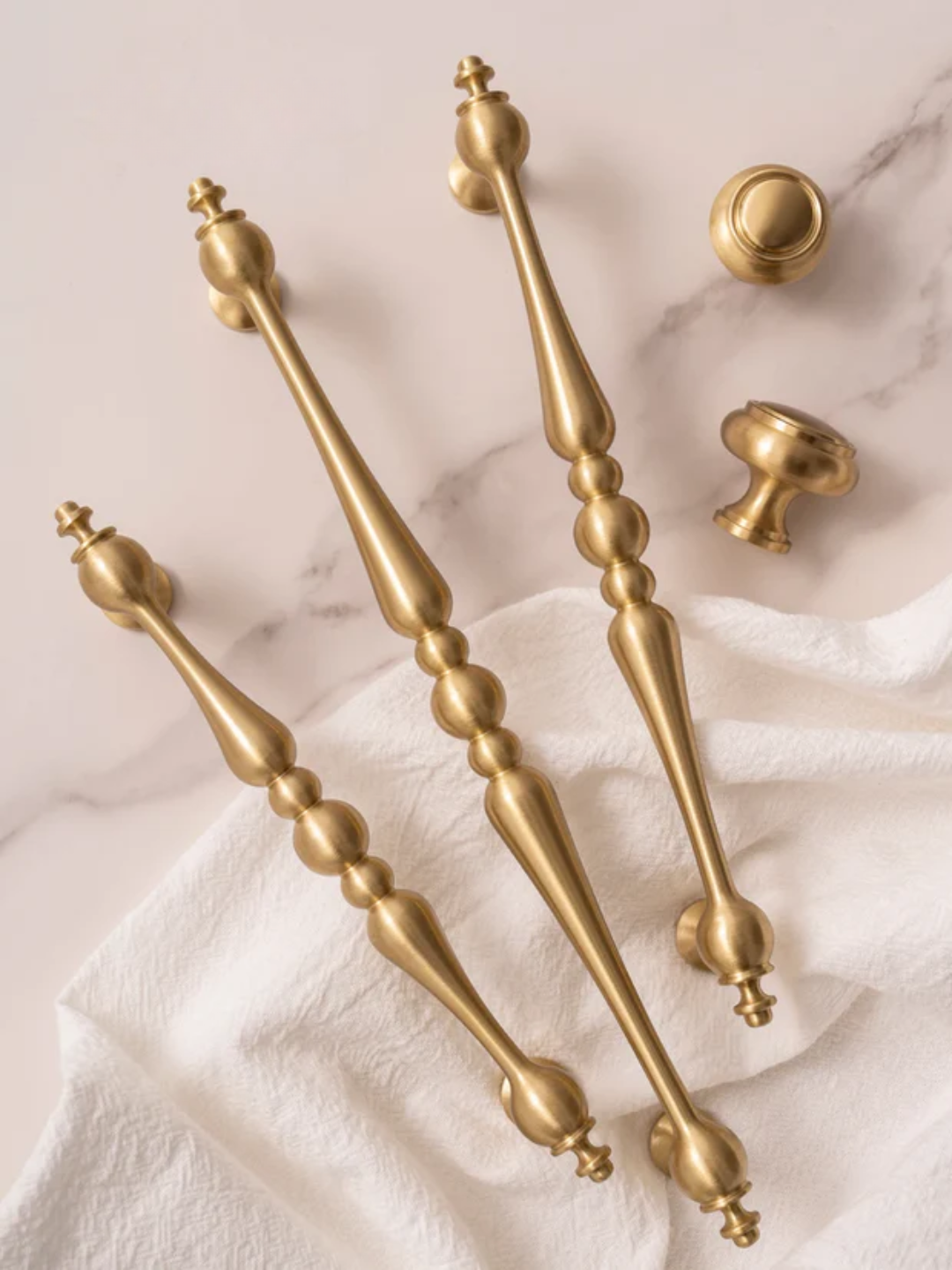 Gold cabinet handles and knobs on a marble surface