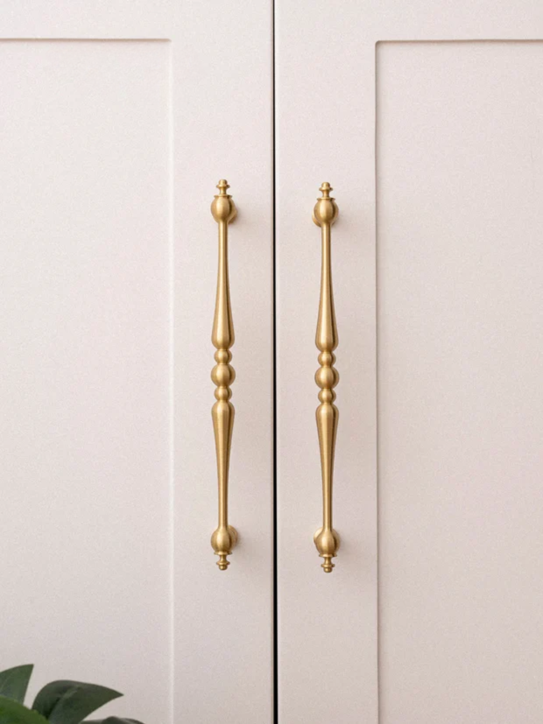Close-up of a cabinet with gold handles on a light background