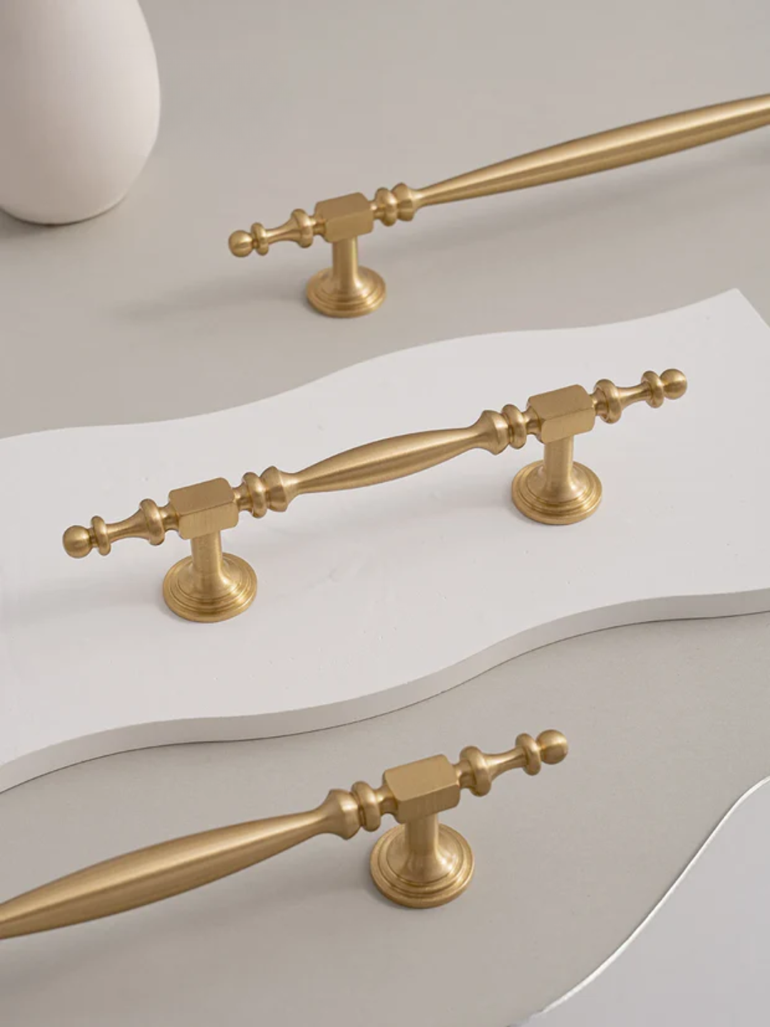 Gold cabinet handles on a white surface with 'Santaya' branding.
