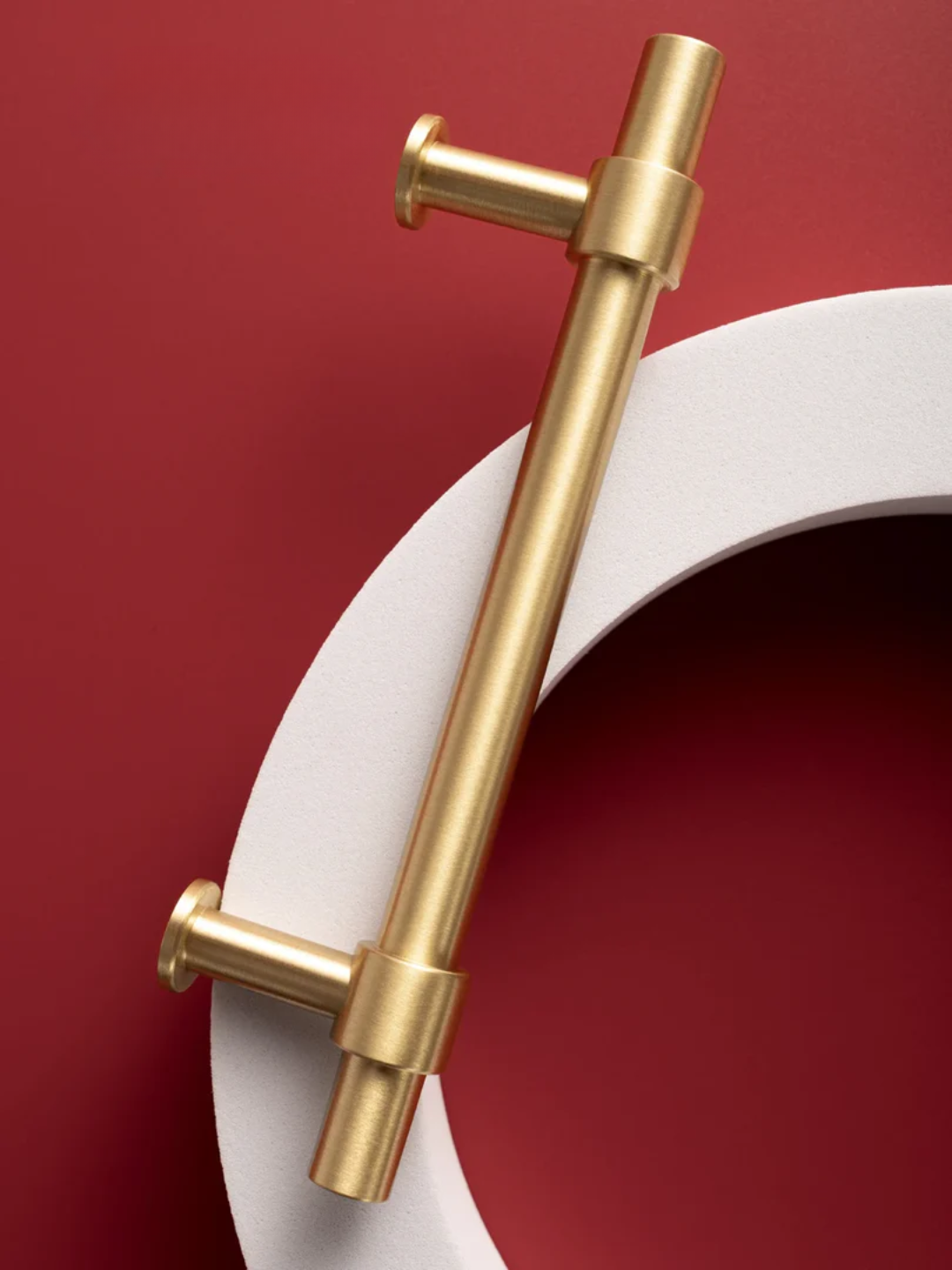 Set of gold cabinet handles on a red and white background