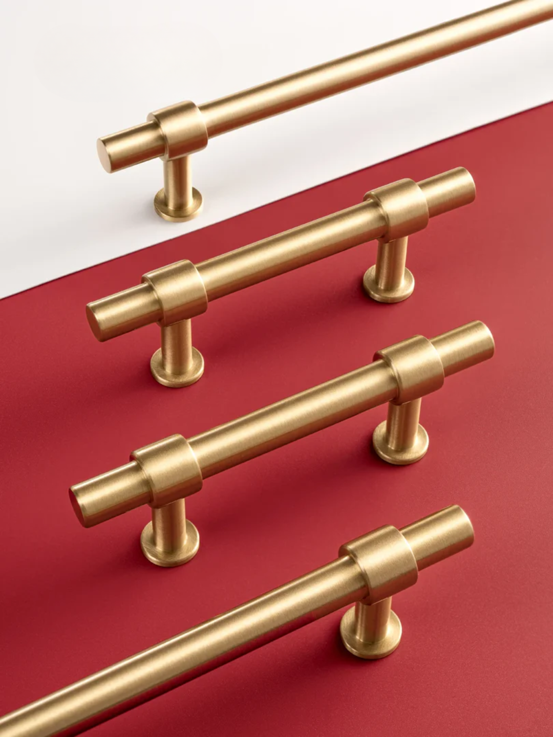 Set of gold cabinet handles on a red and white background
