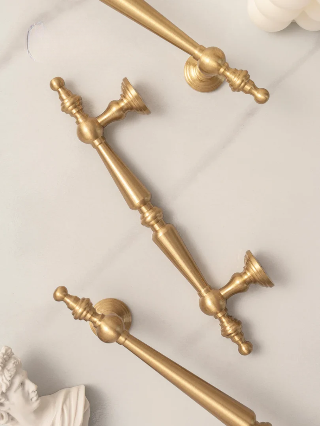 Gold cabinet handles on a light background with 'Santaya' branding.
