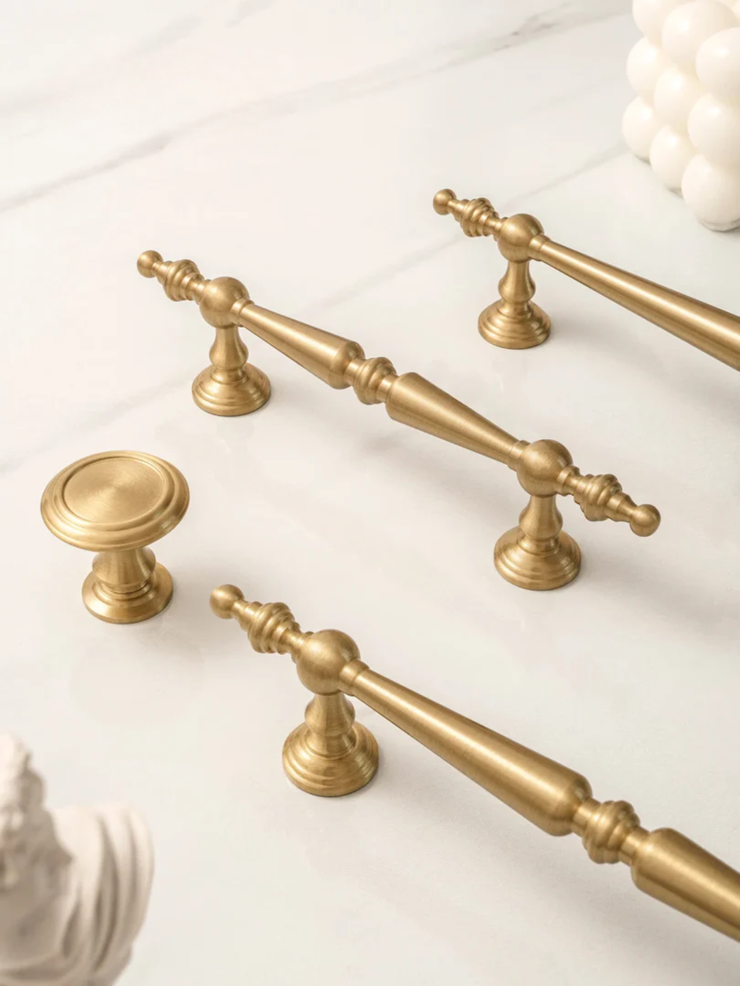 Set of gold cabinet handles and knobs on a white background