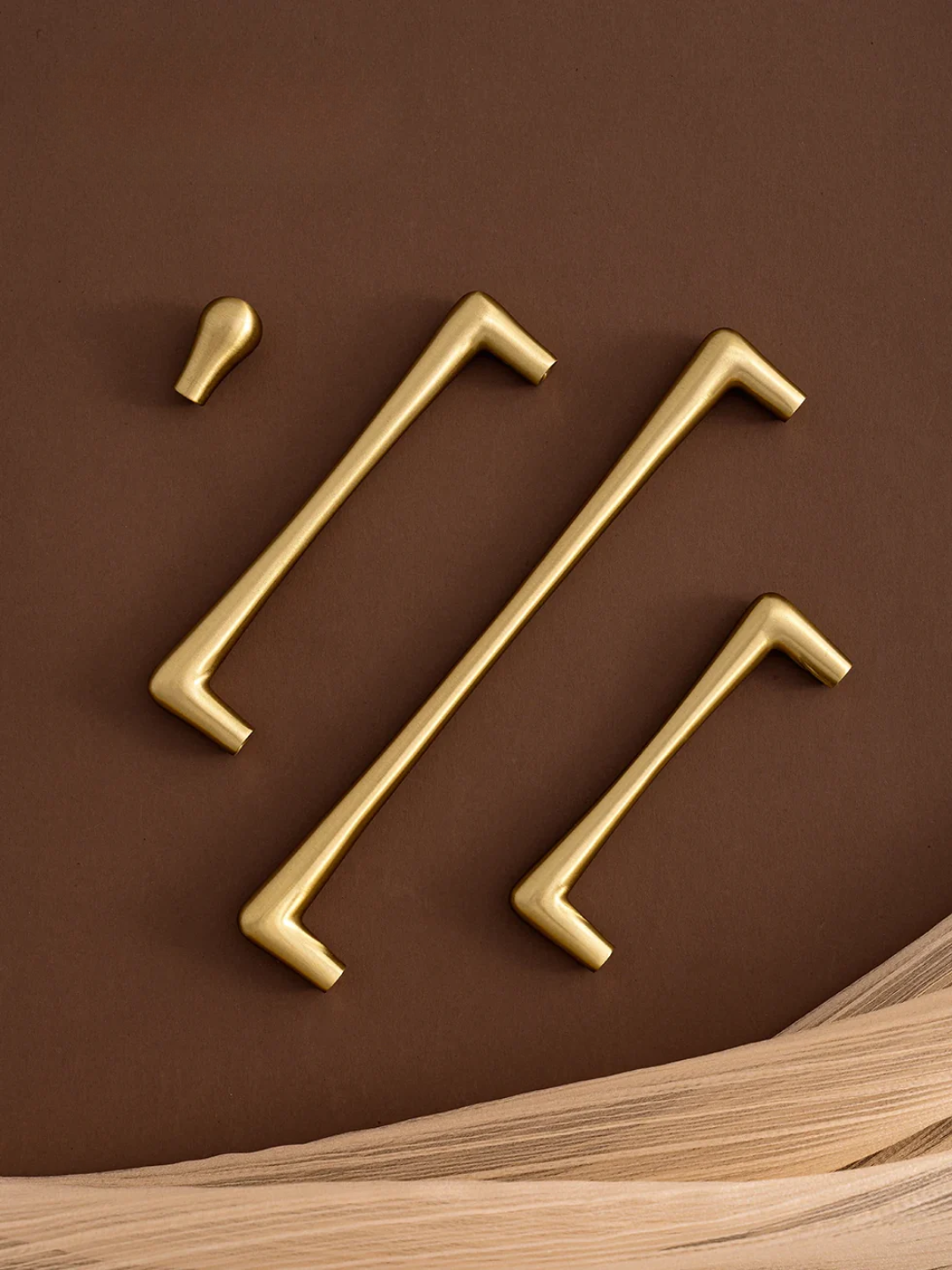 Set of gold cabinet handles on a brown background