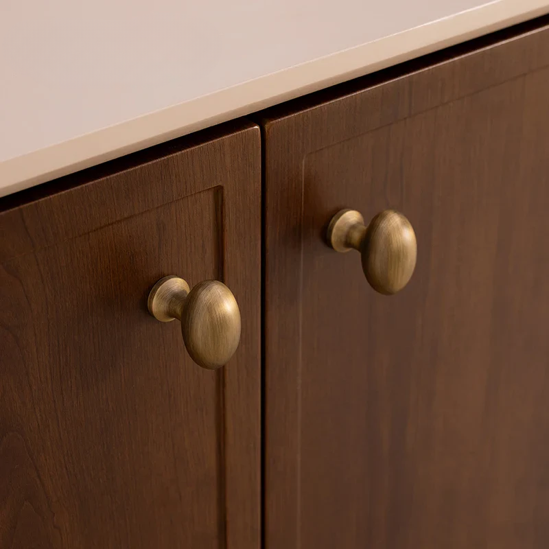 Wooden cabinet with brass knobs on a neutral background