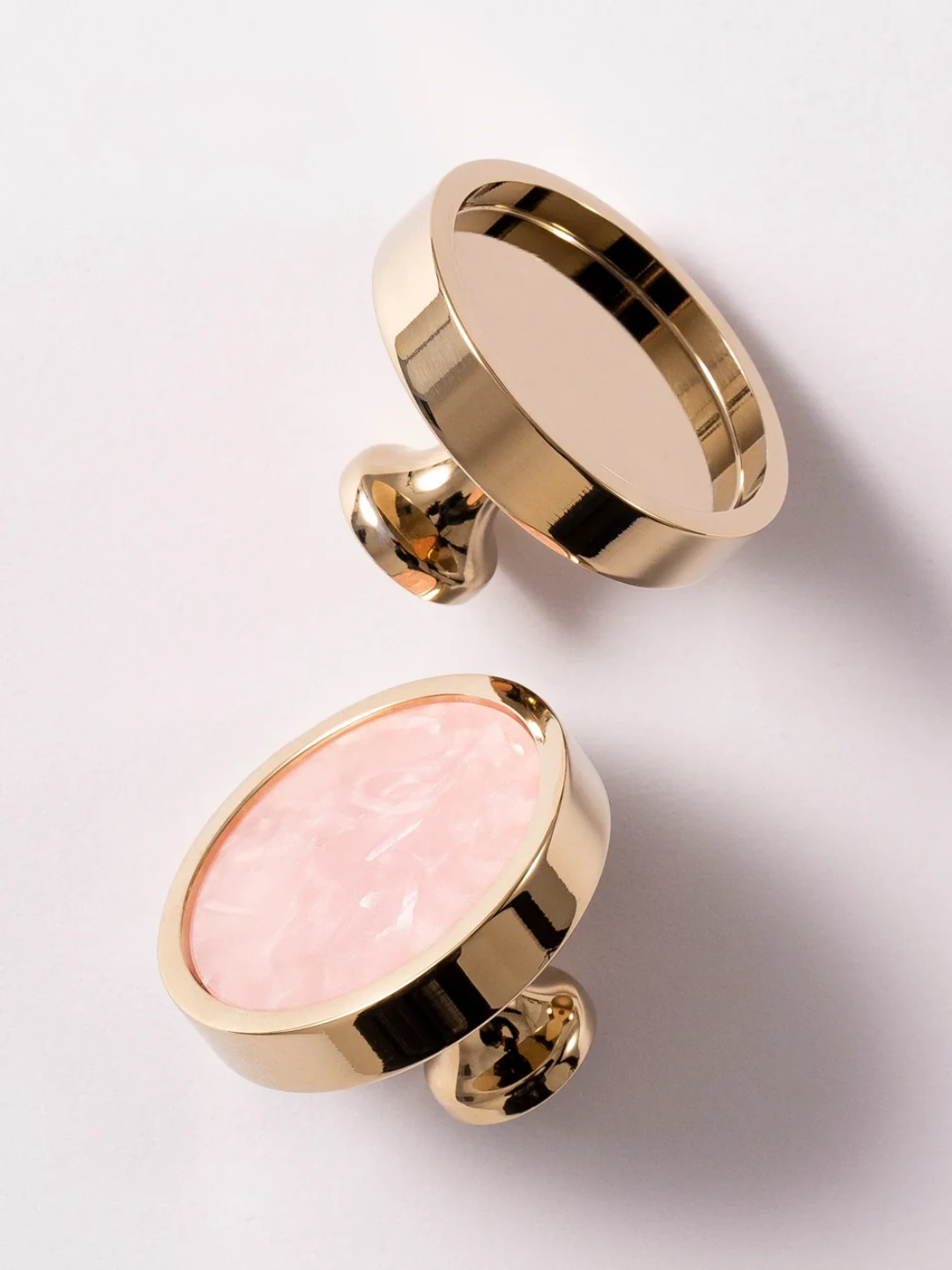Two round objects, one gold and one pink, on a light gray background with 'SANTAYA' branding.