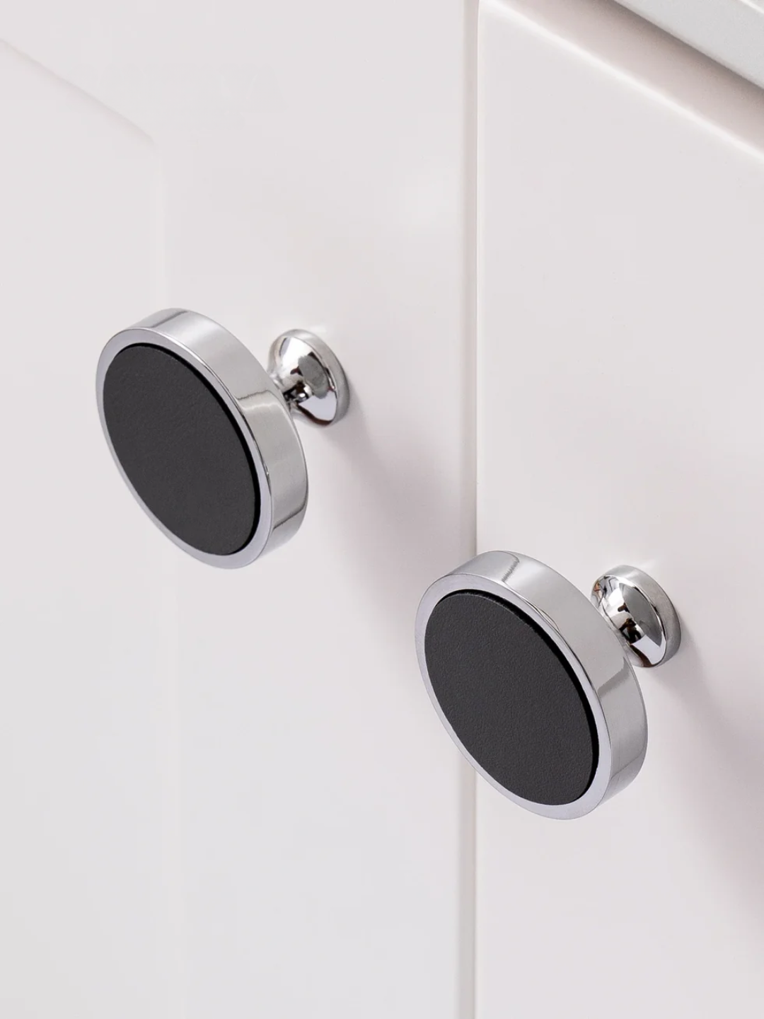 Set of four cabinet knobs with different finishes on a white surface