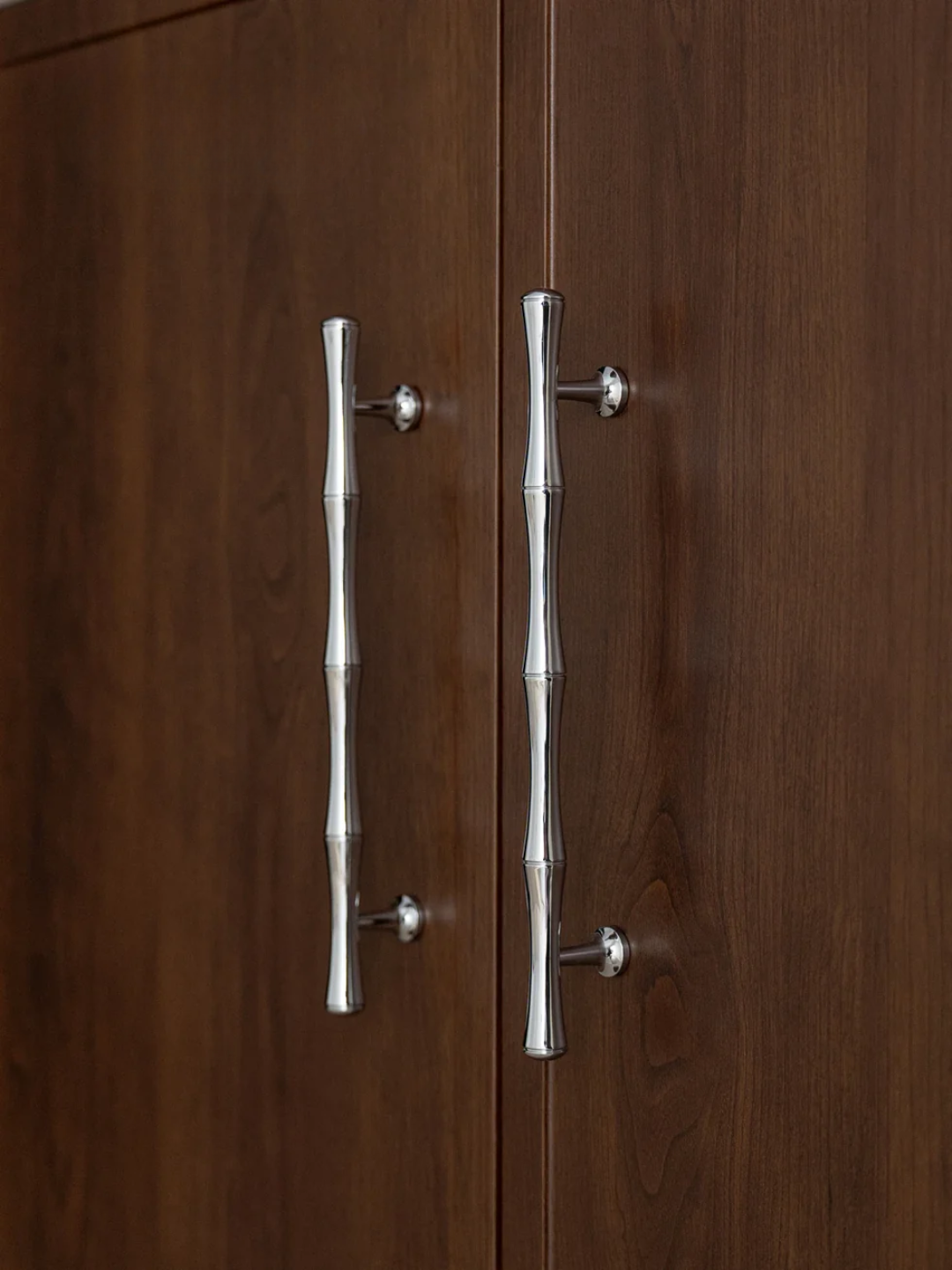 Close-up of a wooden cabinet with metallic handles