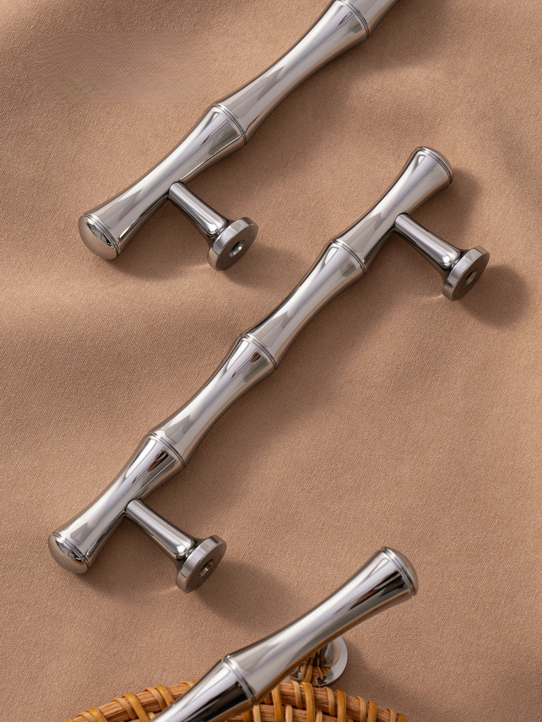 Silver bamboo-style handles on a brown fabric background