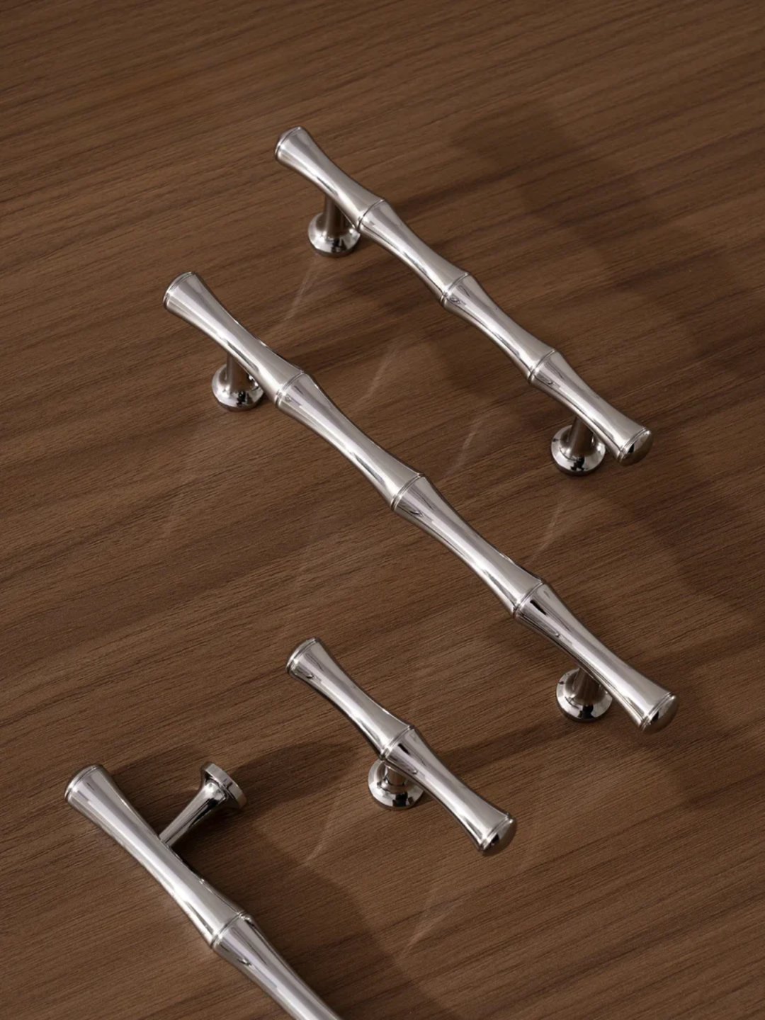 Set of silver cabinet handles on a wooden surface