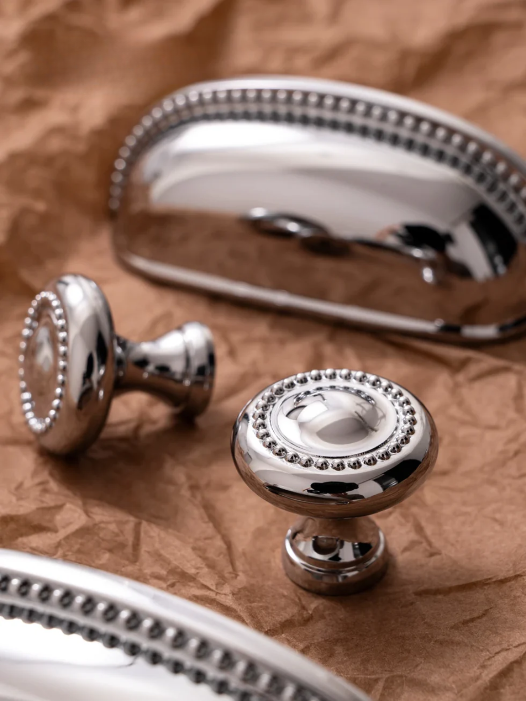 Silver cabinet knobs on a textured brown surface