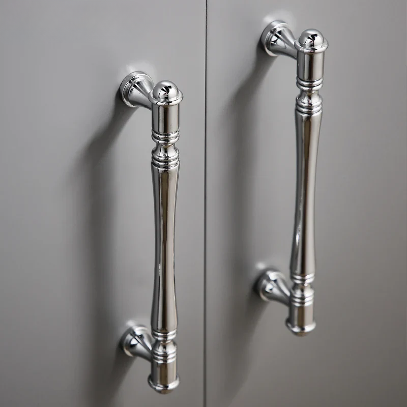 Pair of silver cabinet handles on a gray door