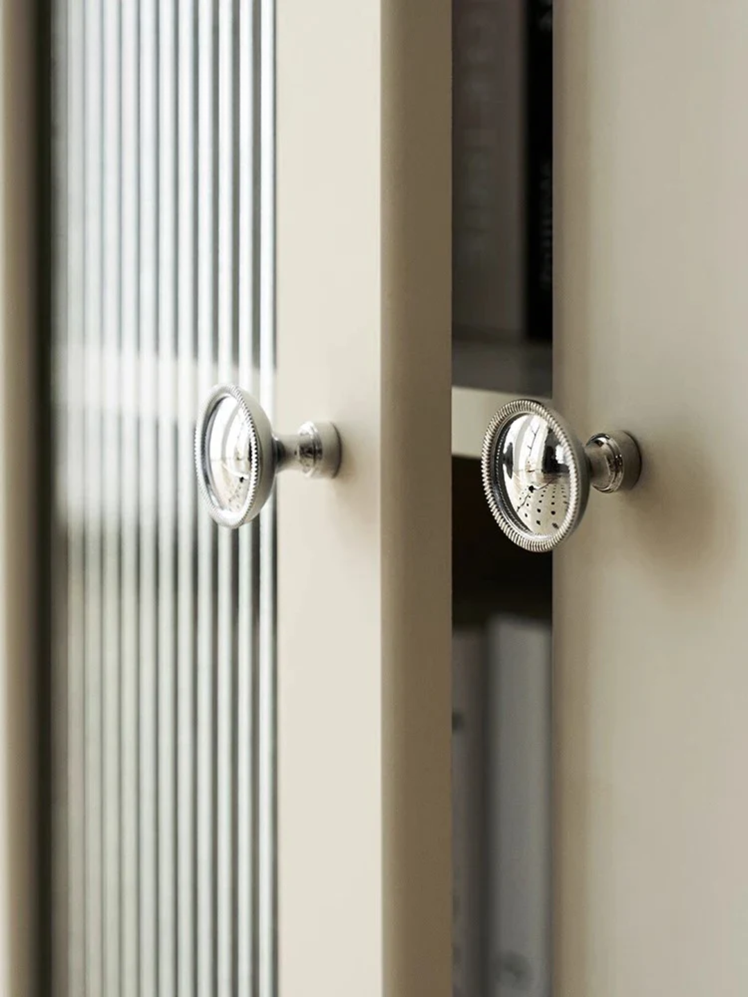 Close-up of a cabinet with metallic knobs on a neutral background