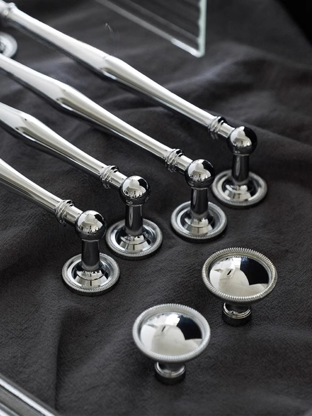 Silver towel bar and hooks on a dark fabric background