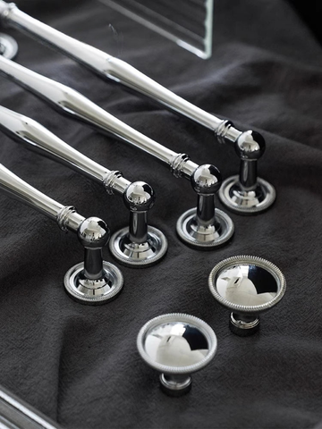 Silver towel bar and hooks on a dark fabric background