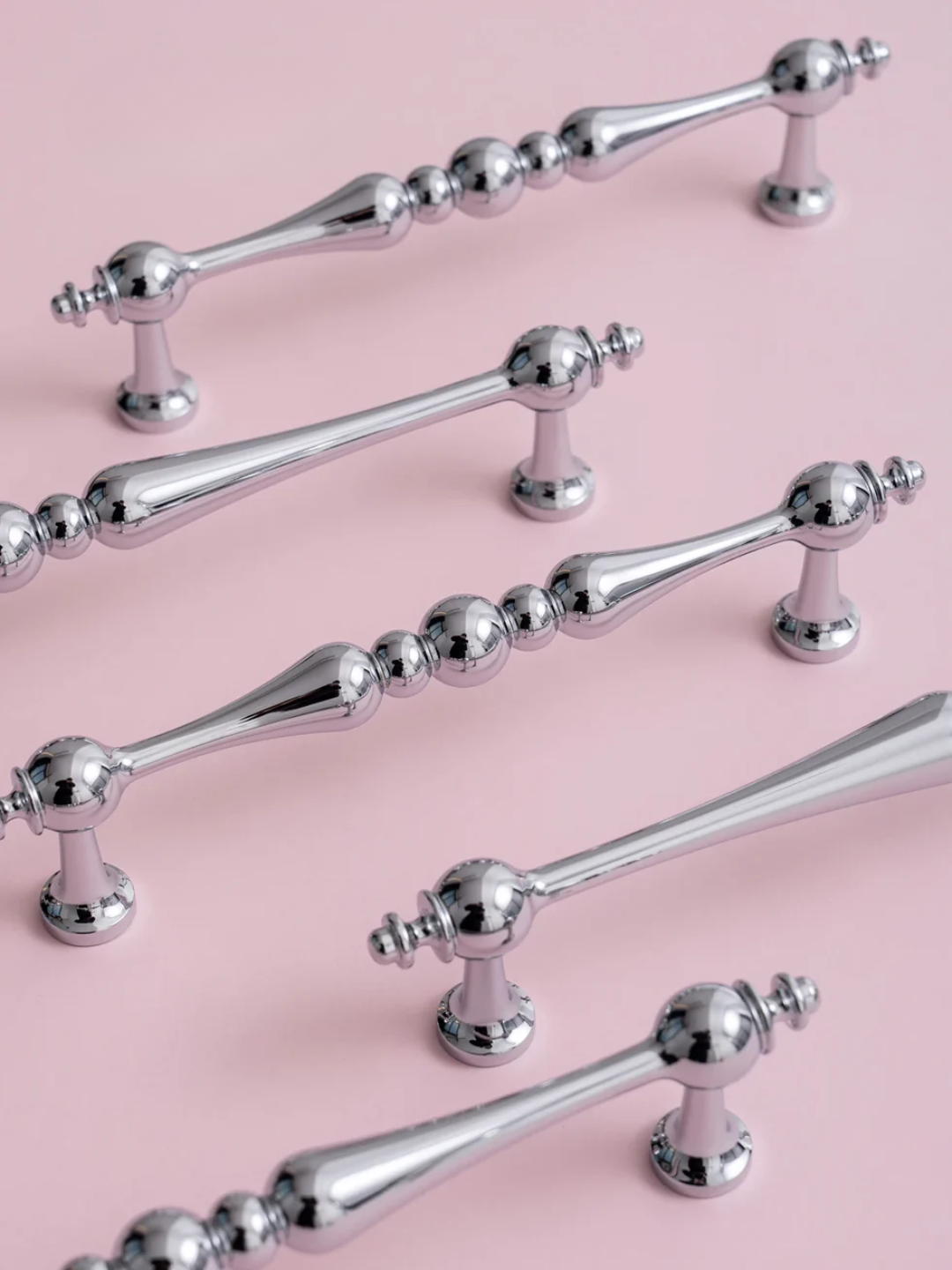 Set of silver handles on a pink background