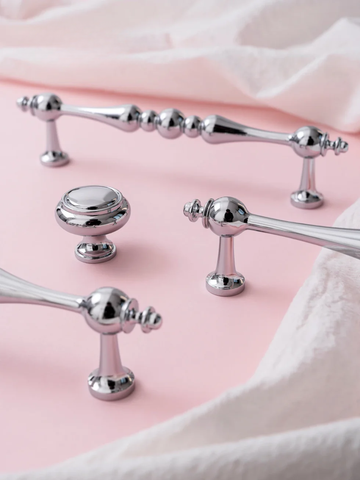 Silver bath accessories on a pink surface