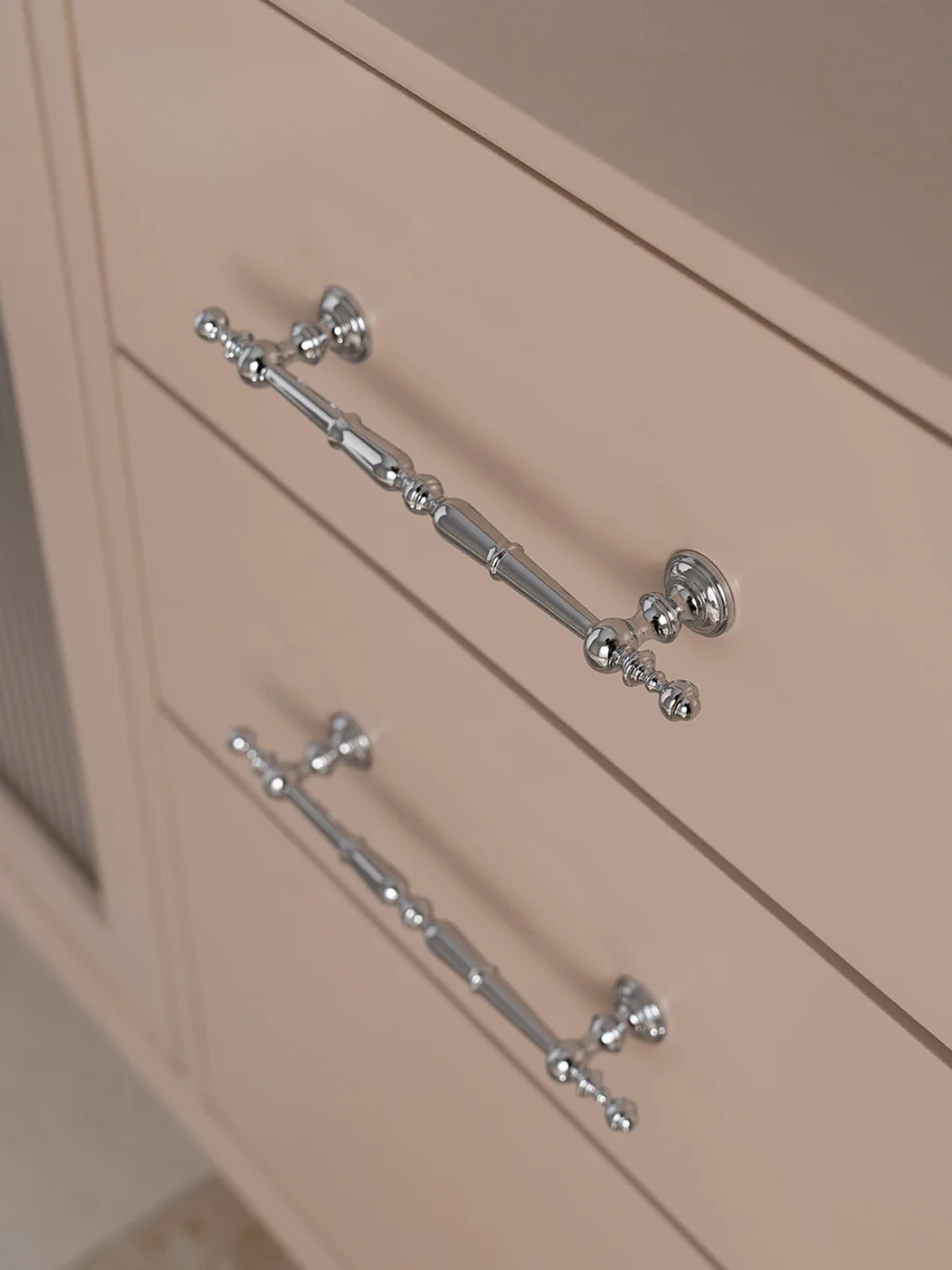 Close-up of beige cabinets with decorative silver handles