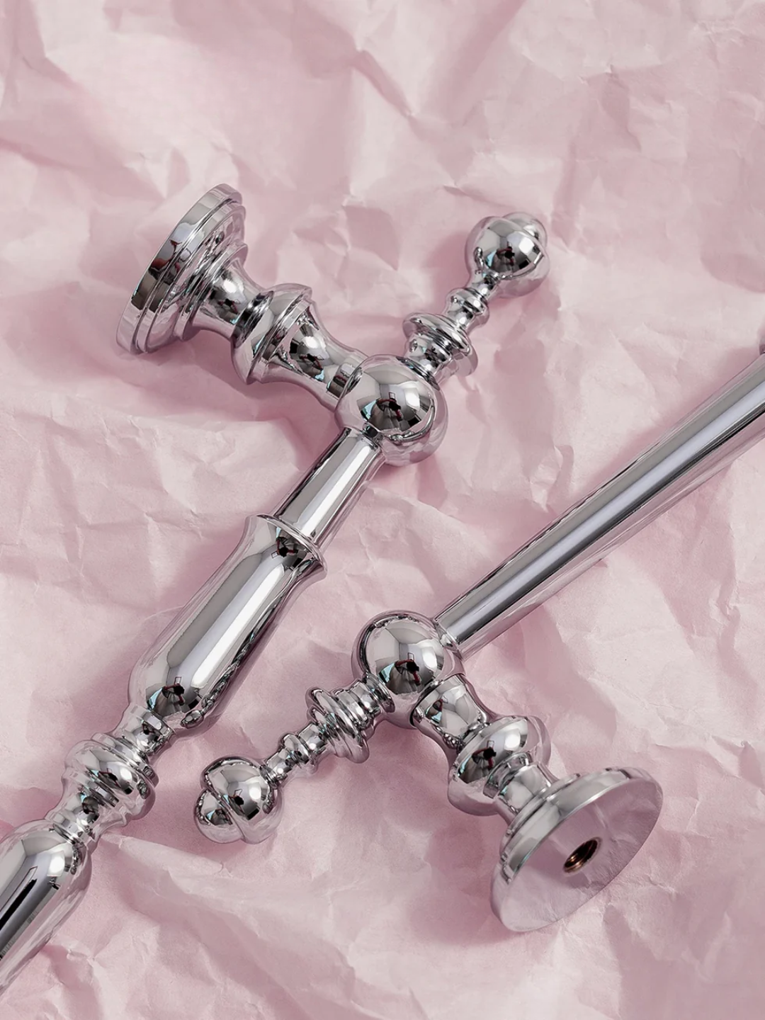 Silver candlestick holders on a pink textured background