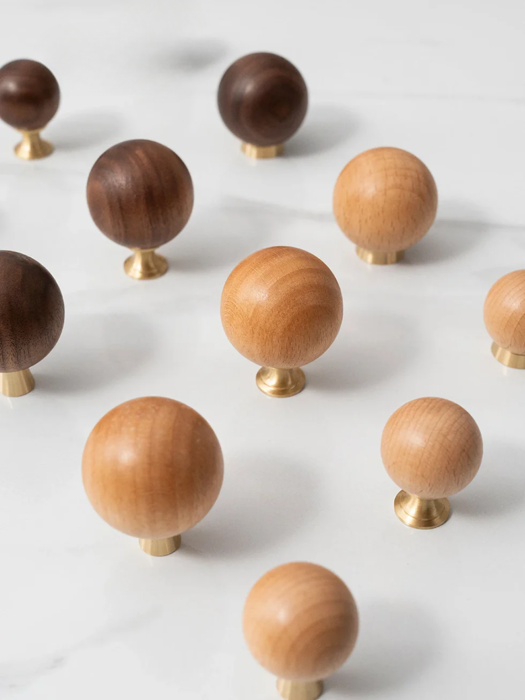 Wooden knobs with gold accents on a wooden tray against a light background