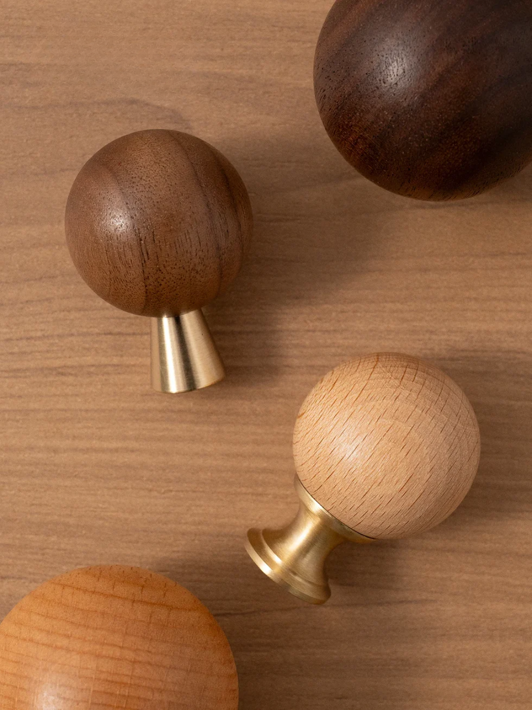 Wooden and brass door knobs on a wooden surface
