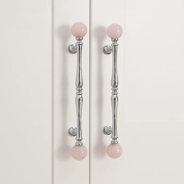 Cabinet doors with pink spherical knobs on a white background
