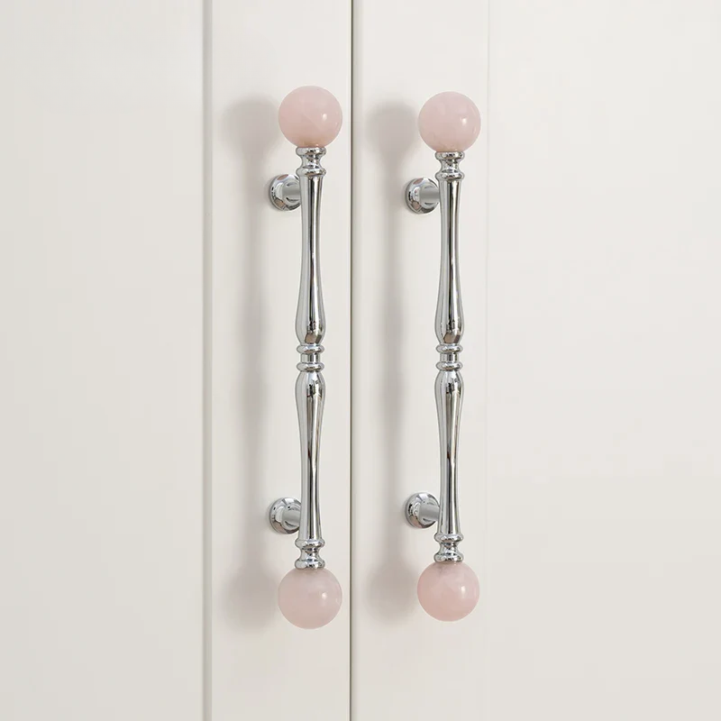Cabinet doors with pink spherical knobs on a white background