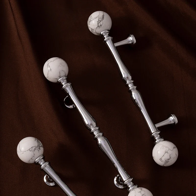 Decorative metal rod with marble ball ends on a brown background