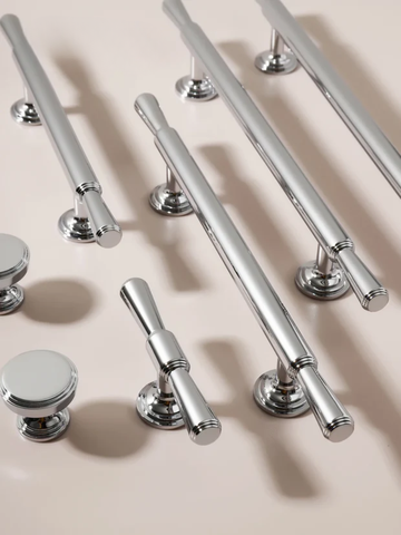 Collection of silver cabinet handles and knobs on a beige background
