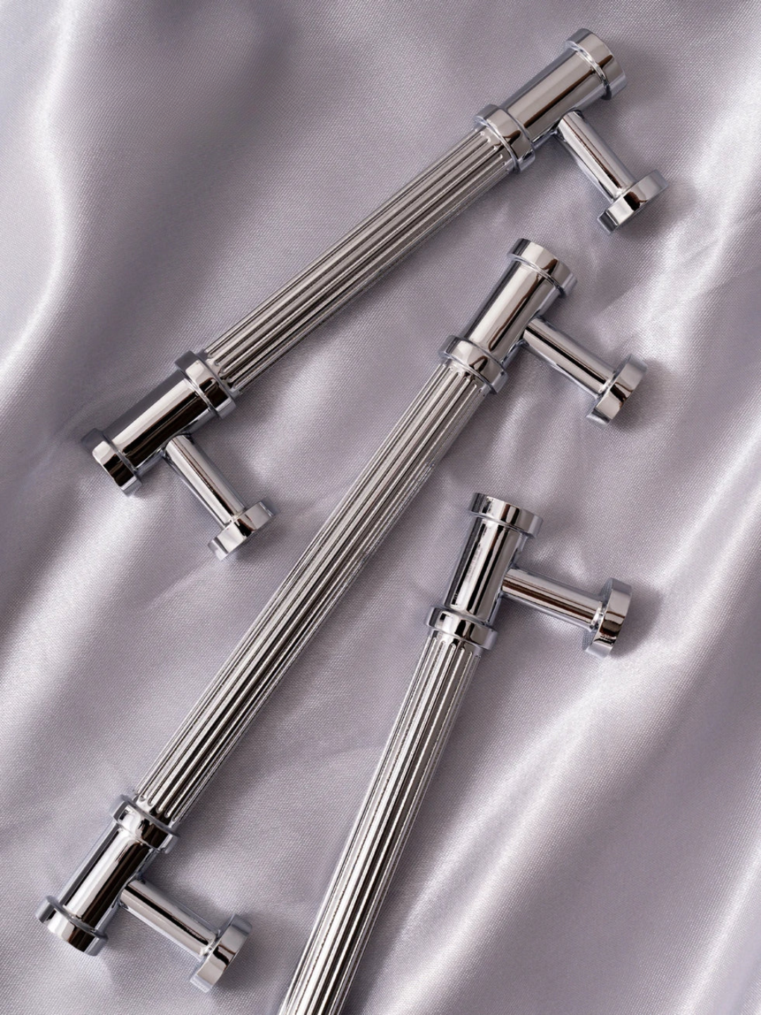Set of metallic kitchen or bathroom fixtures on a reflective surface