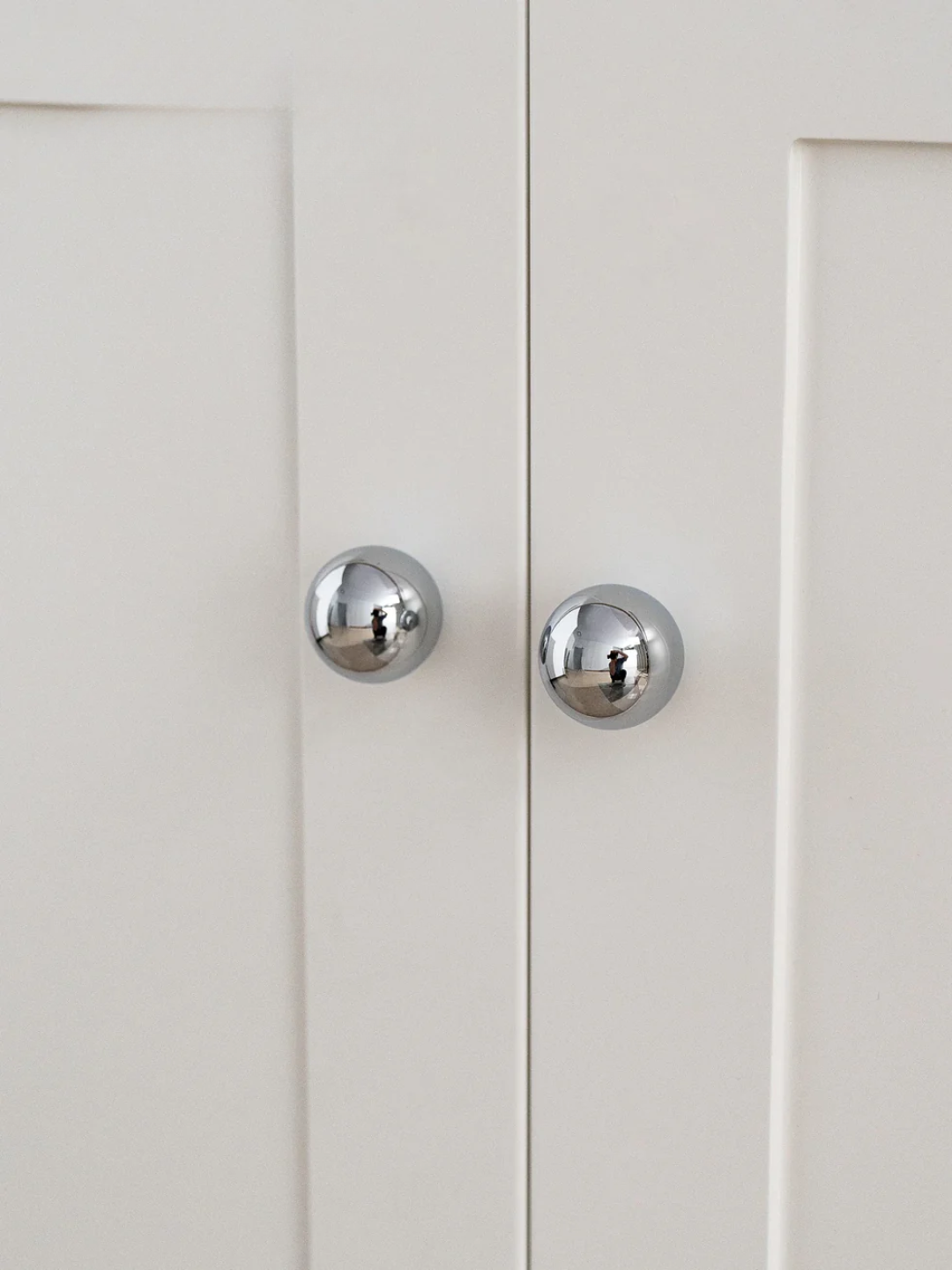 Close-up of a white cabinet with silver knobs