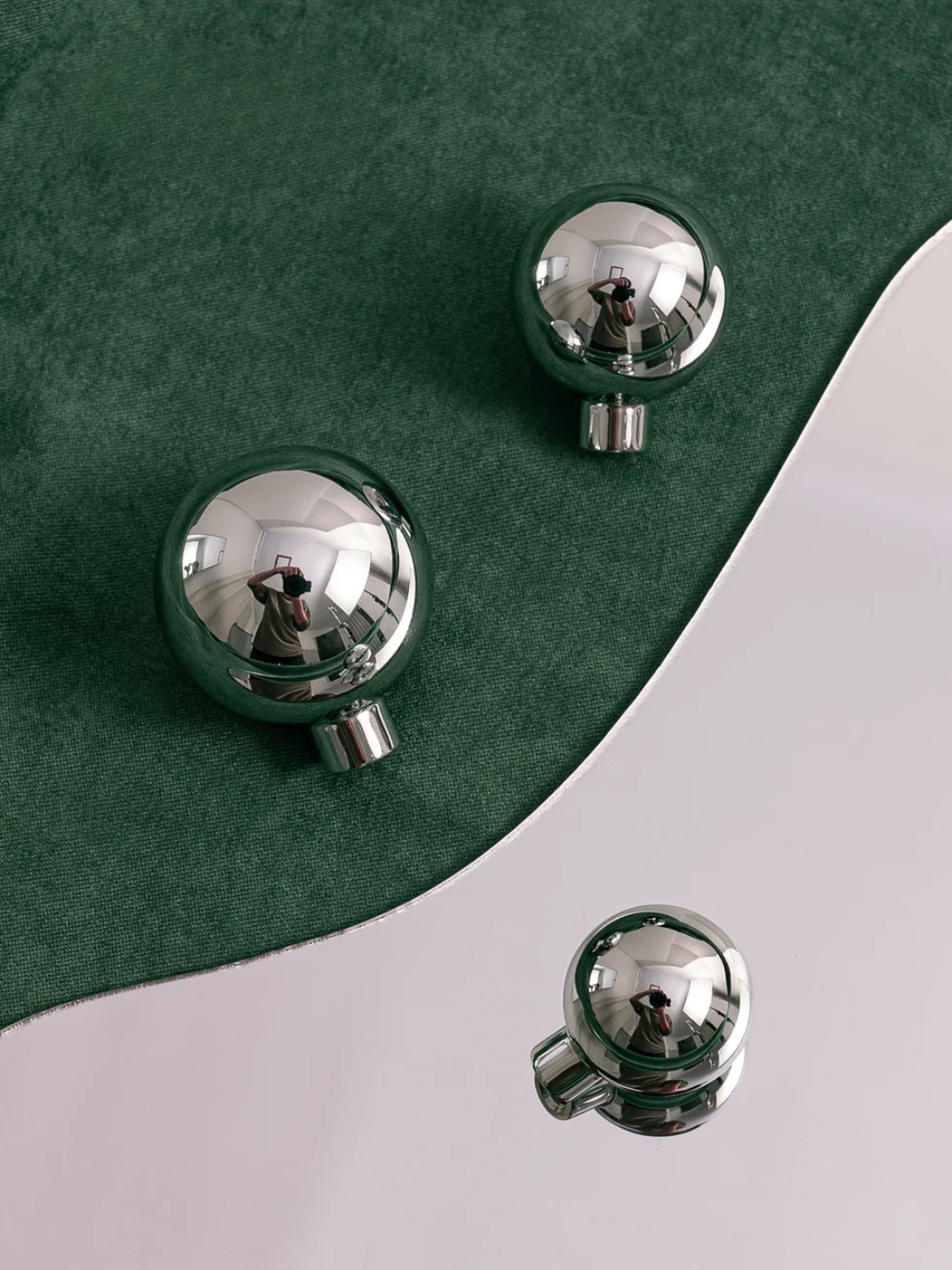 Silver knobs on a green and white surface