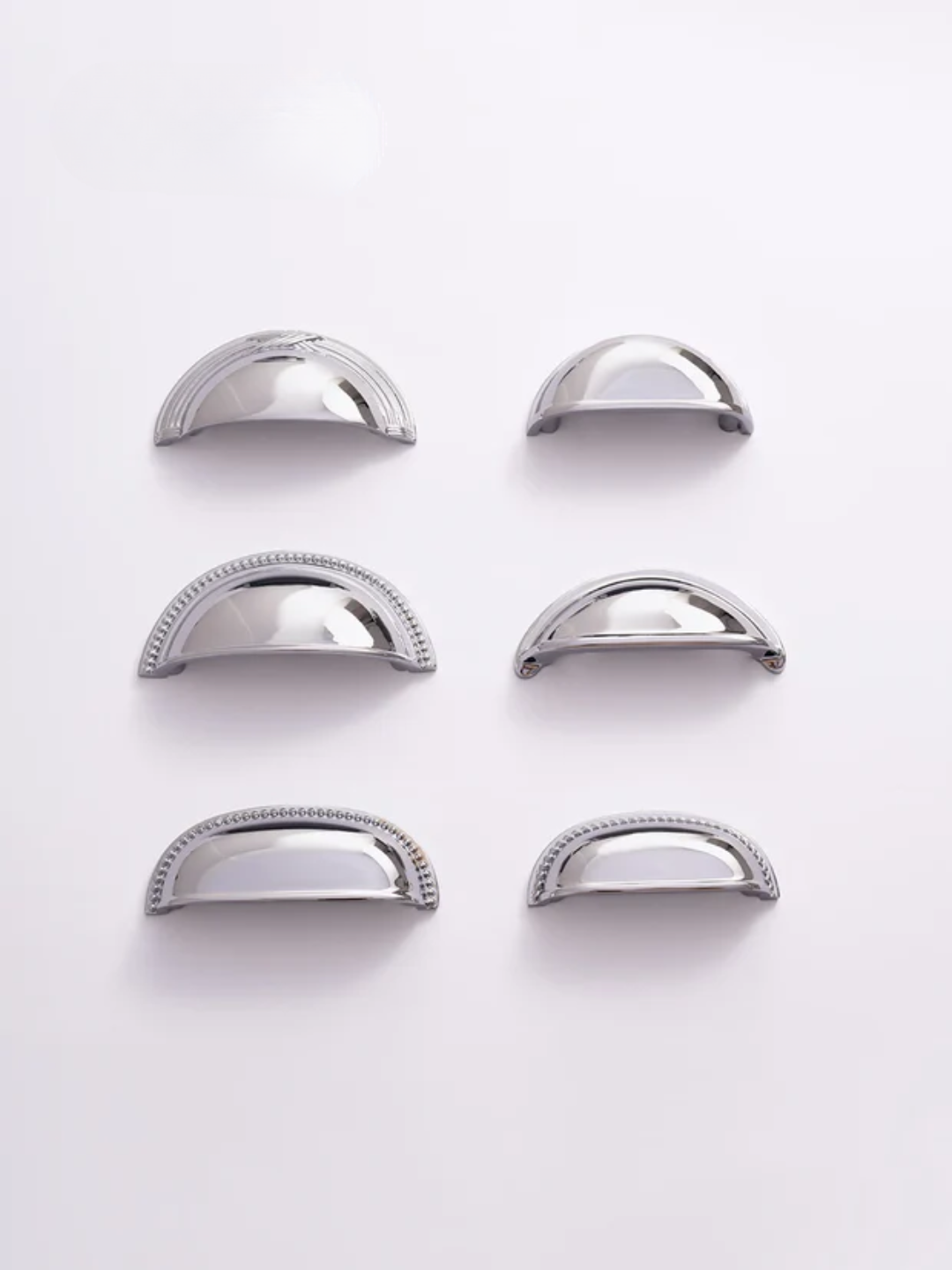 Set of six silver metallic drawer pulls on a white background
