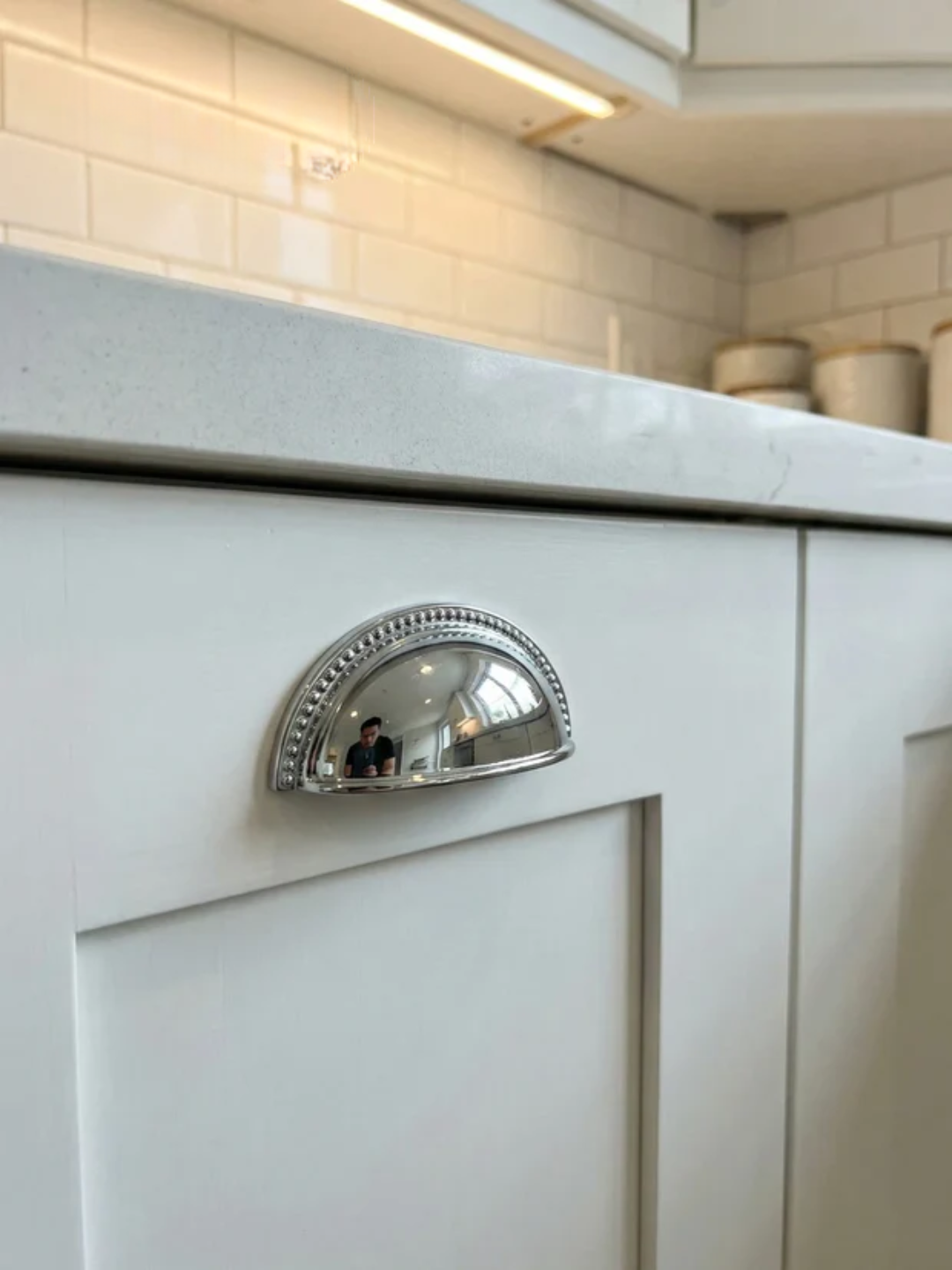 Close-up of a kitchen cabinet with a decorative handle, featuring the Santaya brand.