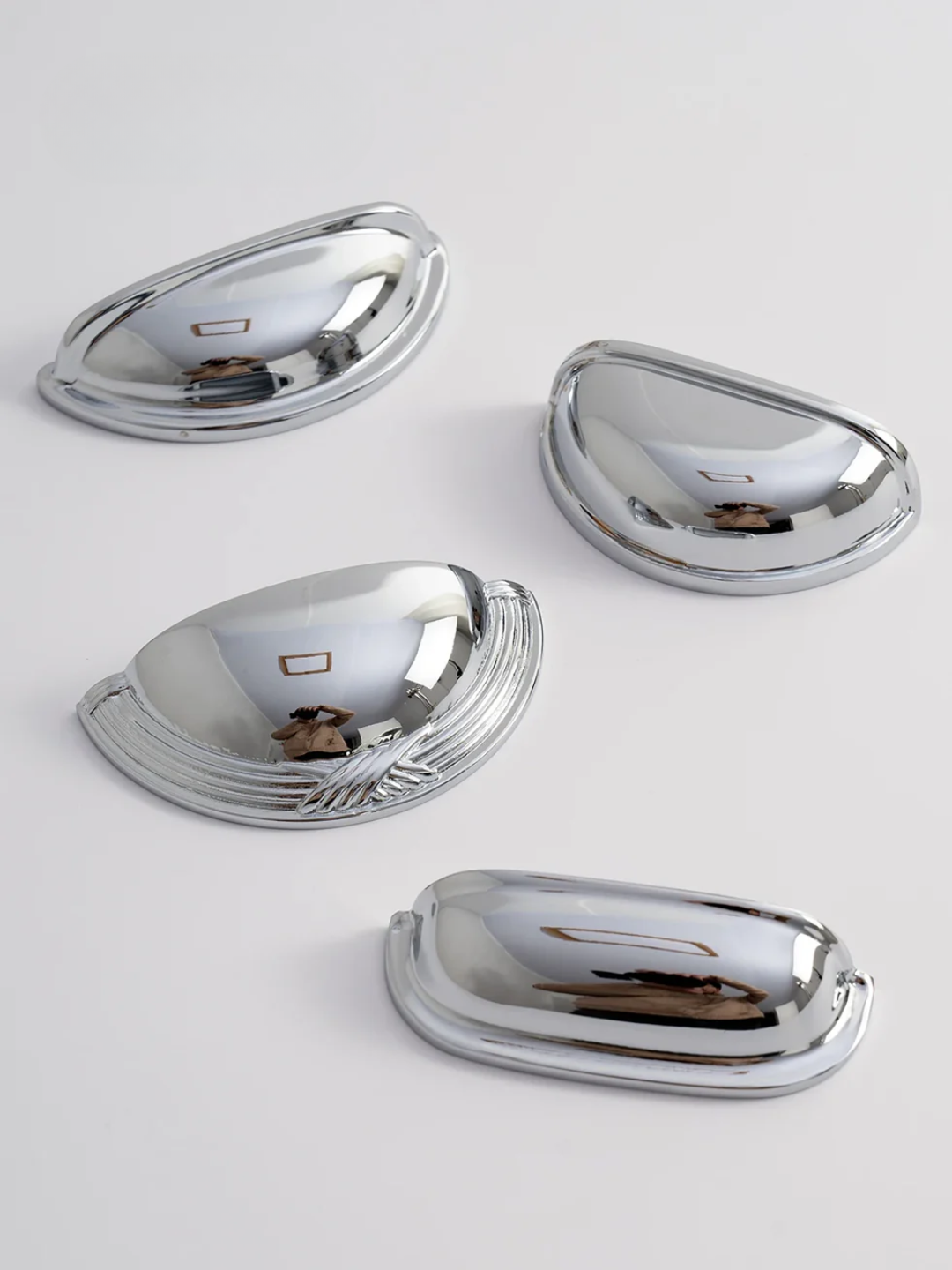 Set of four chrome car fender flares on a white background