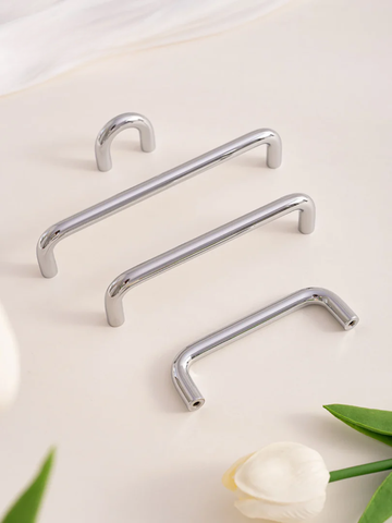Set of four silver handles on a light background with a white flower and green leaves.
