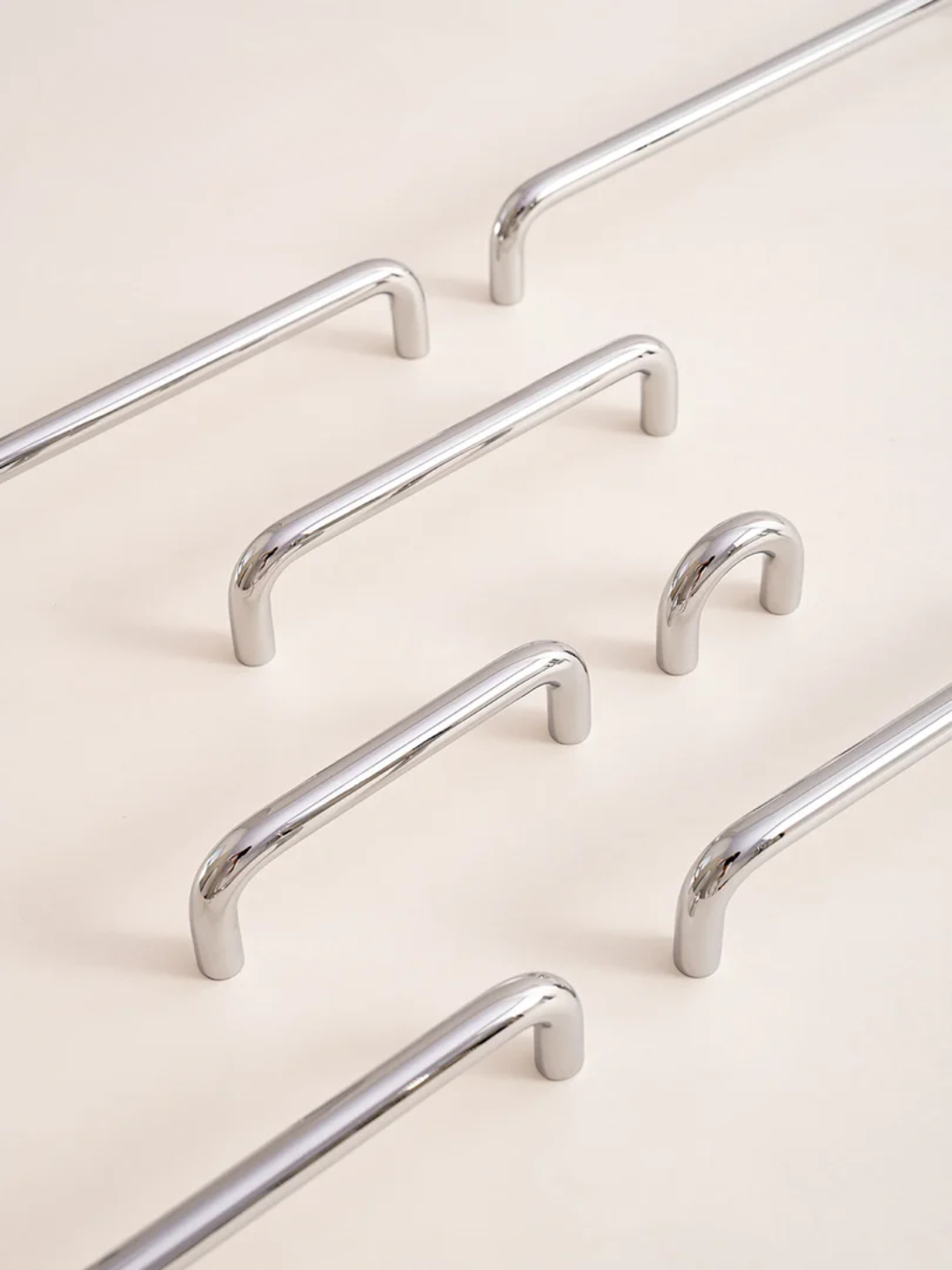 Set of four silver handles on a light background with a white flower and green leaves.