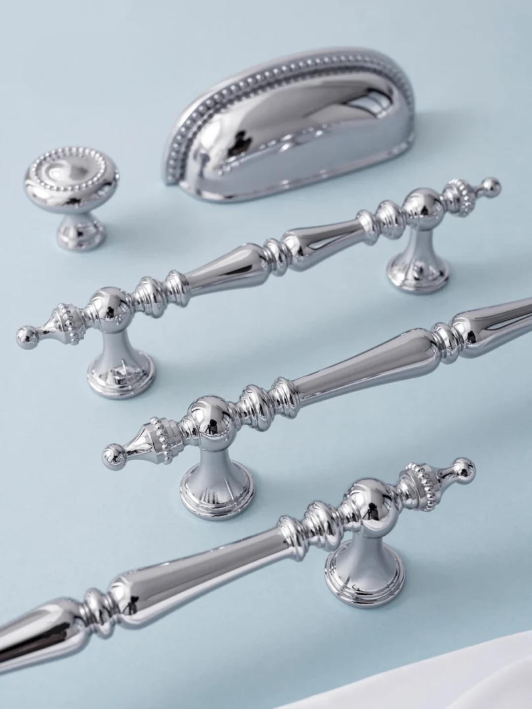 Set of silver cabinet handles on a light blue background