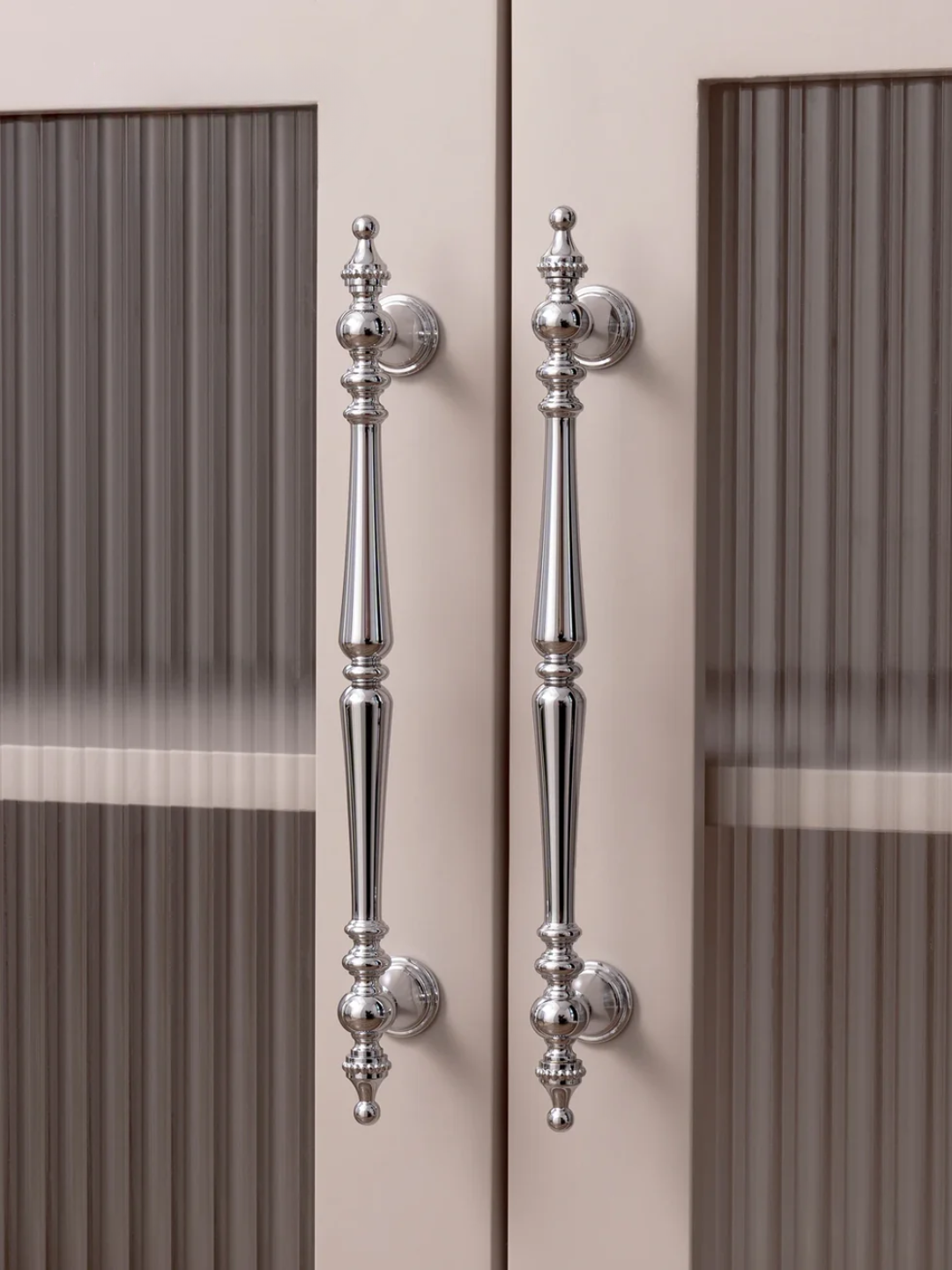 Close-up of decorative silver handles on a door with a blurred background