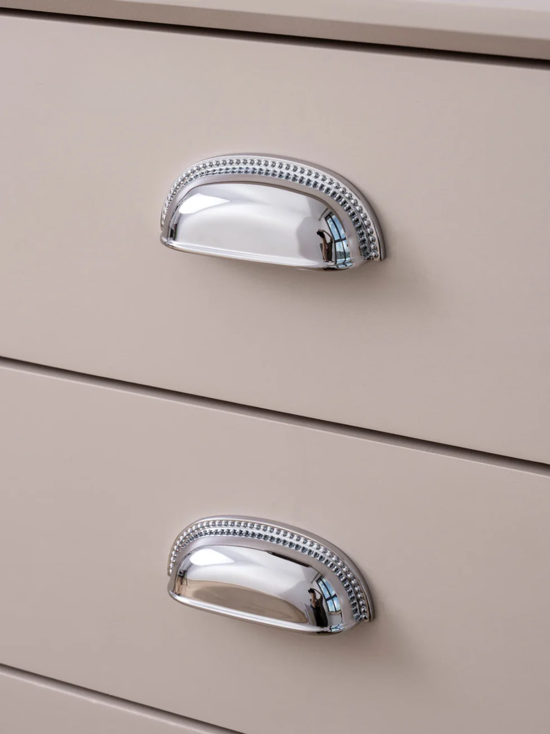 Close-up of beige drawers with silver handles