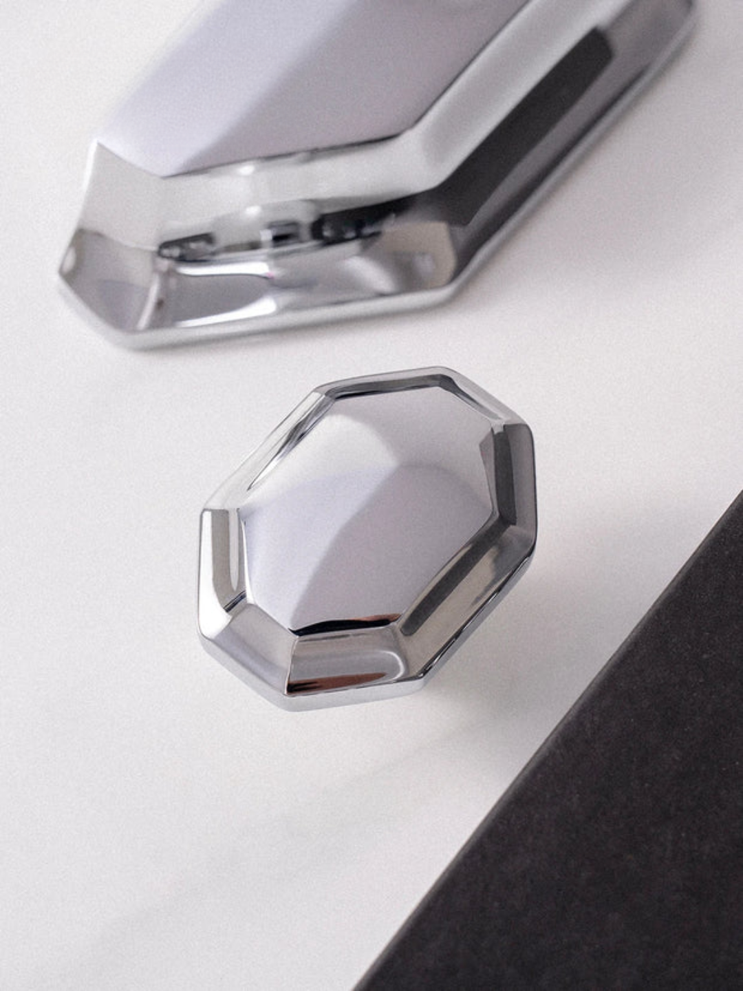 Close-up of a metallic hexagonal object on a white surface