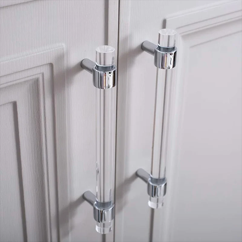 Clear acrylic cabinet handles on a white wooden door